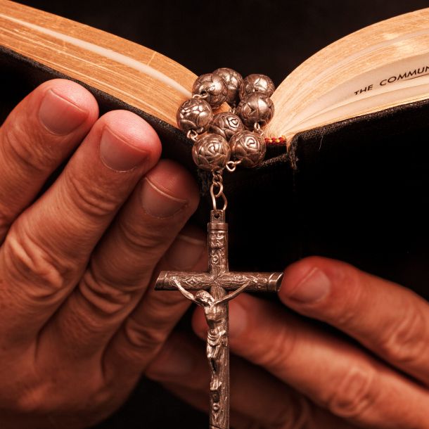 Croce e Bibbia nelle mani primo piano